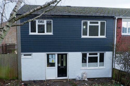 The home at Anderson Green with new dark blue cladding at the top, and white at the bottom.