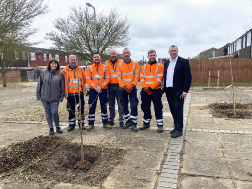 Jo Savage, Steve Collins and five Greatwell Places operatives standing in front of two newly planted Cherry Trees