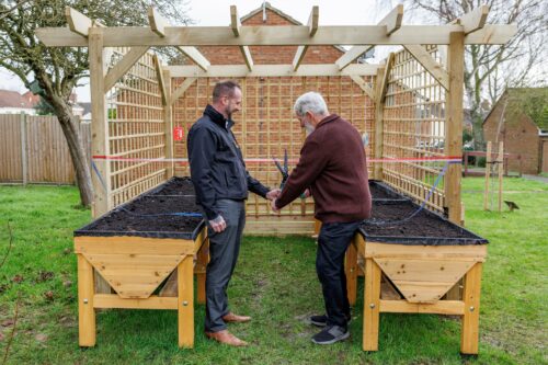 John Ross and customer cutting the ribbon at Earls Barton communal garden opening